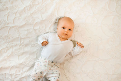 Cute baby girl lying on bed