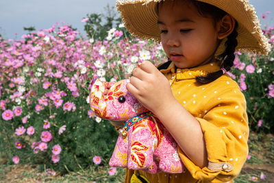 Midsection of woman with pink flower
