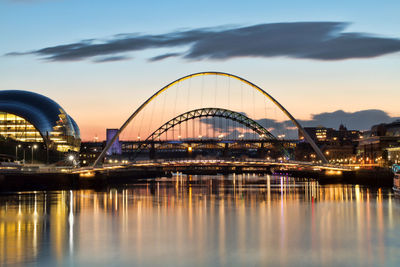 Bridge over river in city against sky