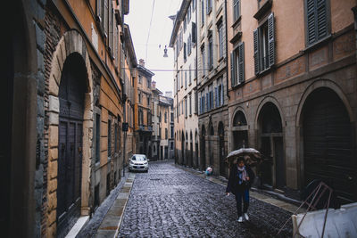 People walking on street amidst buildings in city