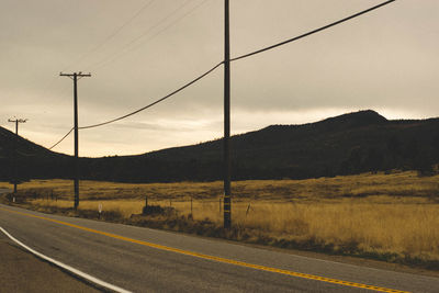 Road by mountain against sky