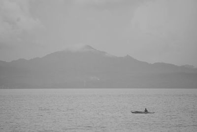 Scenic view of sea and mountains against sky