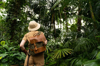 Rear view of woman carrying backpack in forest