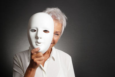 Senior woman wearing mask against black background