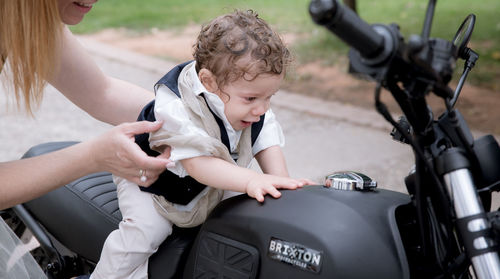 Mother and daughter sitting on motorcycle