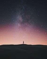 Man on field against sky at night