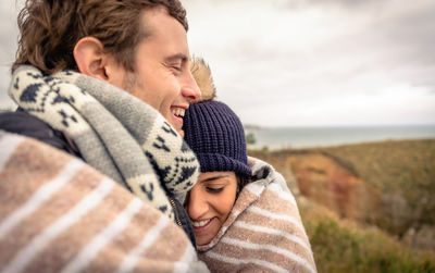 Smiling couple covered with blanket 