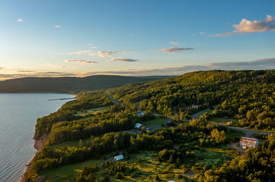 Wide river in wooded valley at sunset in quebec, canada. mountains on horizon. drone type