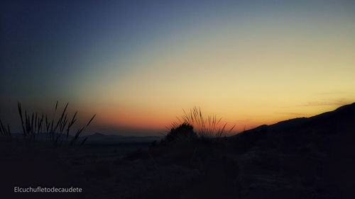 Scenic view of silhouette field against sky during sunset