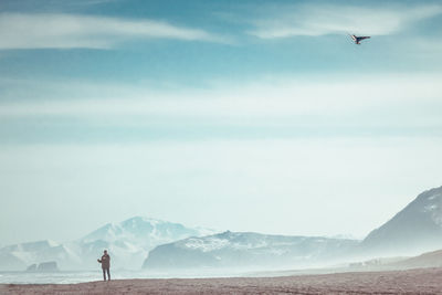 Man flying over mountains against sky