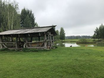 Built structure on field by trees against sky