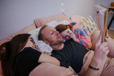 Close up portrait of father reading to his daughters