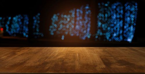 Close-up of wooden table against blue wall