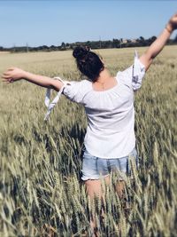 Woman standing on field against sky