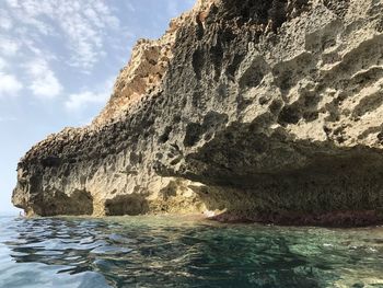 Rock formation in sea against sky