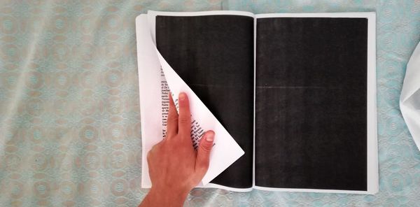 Midsection of person reading book on table