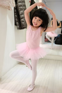 Portrait of cute little ballet girl with hands holding love