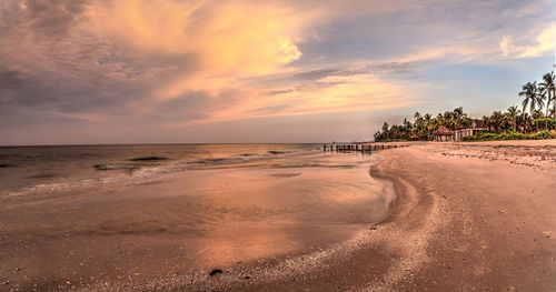 Old pier in the ocean at port royal beach at sunrise in naples, florida