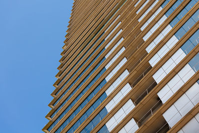 Low angle view of skyscraper against clear blue sky