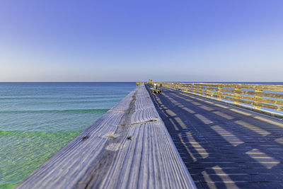 Scenic view of wooden pier against clear blue sky and the gulf of mexico 