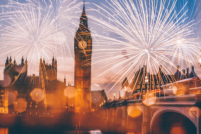 Firework display over city lit up at night