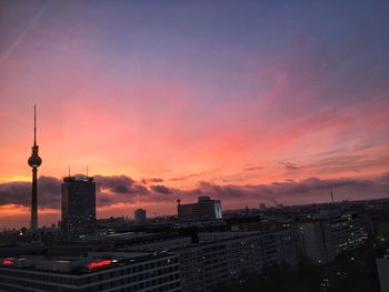 Illuminated city against sky during sunset