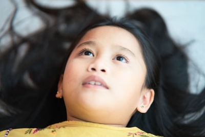 Close-up portrait of cute girl looking up