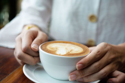 Midsection of woman holding coffee cup