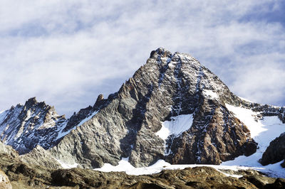 Snowcapped mountains against cloudy sky