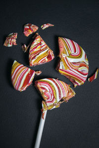 High angle view of multi colored candies against black background