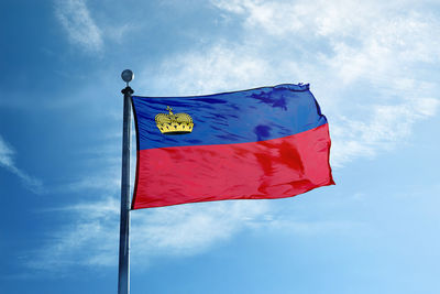 Low angle view of flag against blue sky