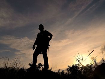 Rear view of silhouette man against sky during sunset