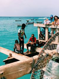 People fishing in sea against sky