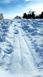 Snow covered field against sky