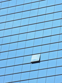 One open window glass in blue glass panel of high building