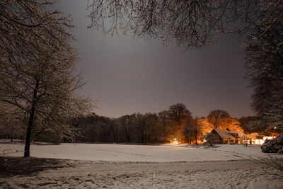 Scenic view of house in snow area at night
