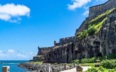 Built structure by sea against blue sky