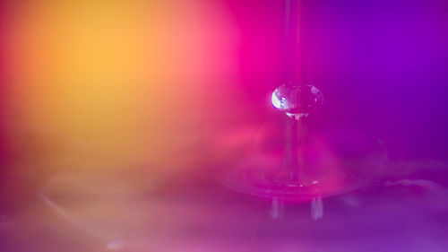 Close-up of water drop falling on glass