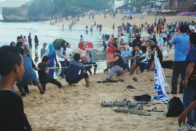 People playing tug-of-war at beach
