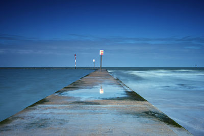 Jetty in sea against sky