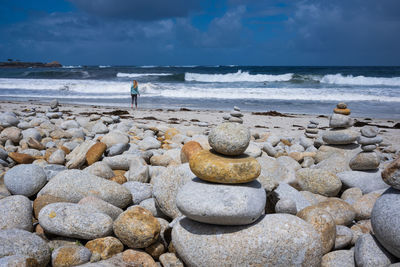 Scenic view of rocks on beach against sky