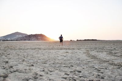 View of man on sand by beach against sky