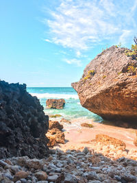 Rock formation on beach against sky