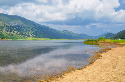 Scenic view of lake against cloudy sky