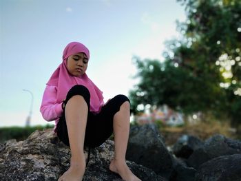 Woman sitting on rock