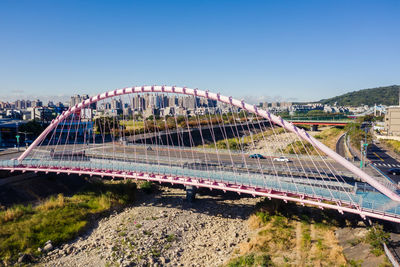 Bridge over cityscape against clear blue sky