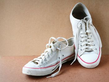 Close-up of shoes on floor against wall