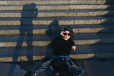 Woman wearing sunglasses sitting on steps