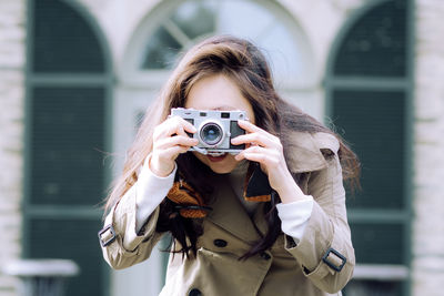 Young woman photographing with camera