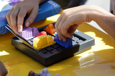 Cropped hands of person playing with toys on table